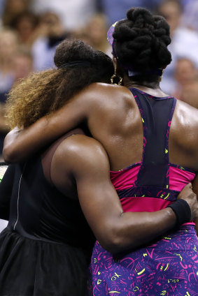 Family ties: Serena Williams (left) embraces her sister Venus after their third round match.