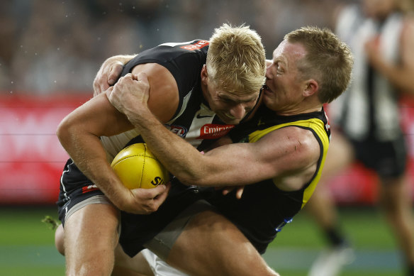 Billy Frampton of the Magpies is tackled by Jack Riewoldt of the Tigers.