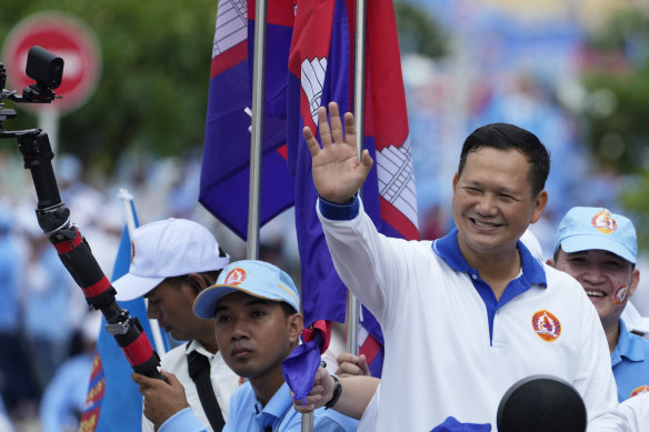 Hun Manet (right), the eldest son of Cambodian leader Hun Sen, greets supporters in Phnom Penh.