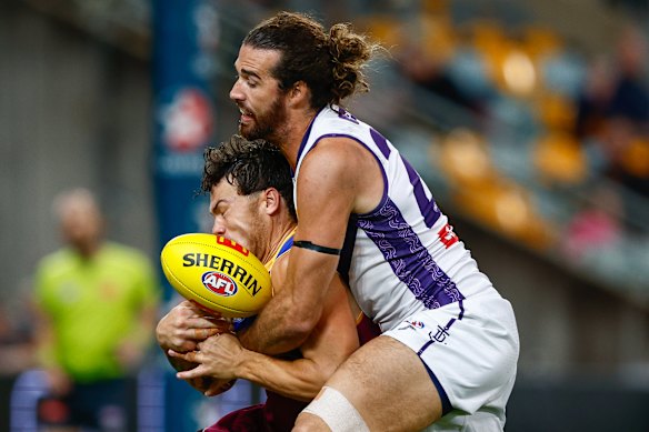 Cam Rayner of the Lions is tackled by Alex Pearce.