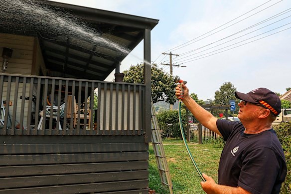 Paul Heyen hoses down his Yea home as fire advanced on the town on Friday.