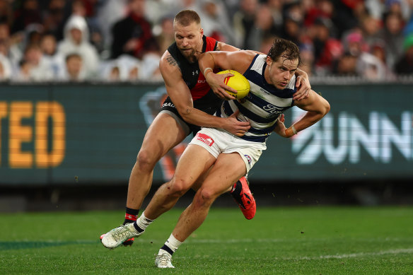 Jake Kolodjashnij of the Cats is tackled by Jake Stringer of the Bombers.