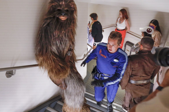 Sammie, the ships mechanic, in blue, leads Chewbacca the Wookie as they sneak through the hallways to escape capture from the First Order.