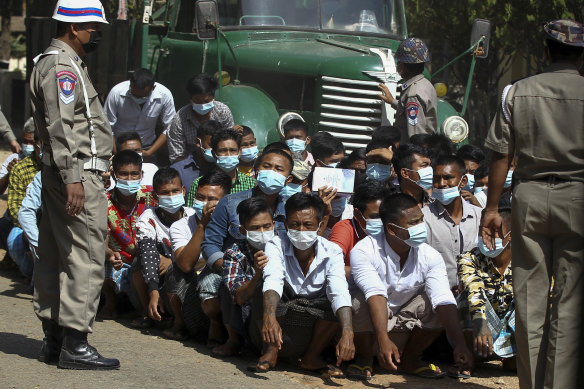 Security forces in Myanmar stand guard over detainees in February.