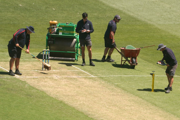 Ground staff inspected the pitch after play on Saturday.