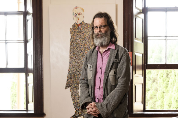 The artist, who goes by the moniker "What", with his portrait of Robert Forster which won last year's Doug Moran Portrait Prize.