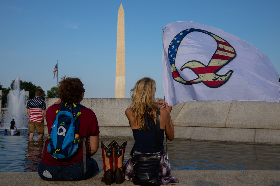 QAnon supporters wait for a military flyover at the World War II Memorial during Fourth of July celebrations last year in Washington, D.C.. MUST CREDIT: Photo for The Washington Post by Evelyn Hockstein