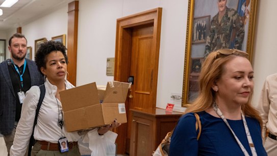 Members of the Pentagon press corps leave the building, carrying their belongings on Wednesday afternoon.