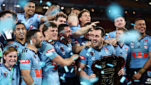 Isaah Yeo prepares to raise the shield surrounded by NSW teammates.