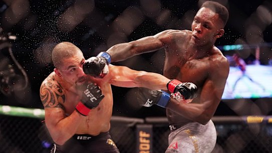 Robert Whittaker (left) is hit by Israel Adesanya (right) as they compete during UFC 243. 