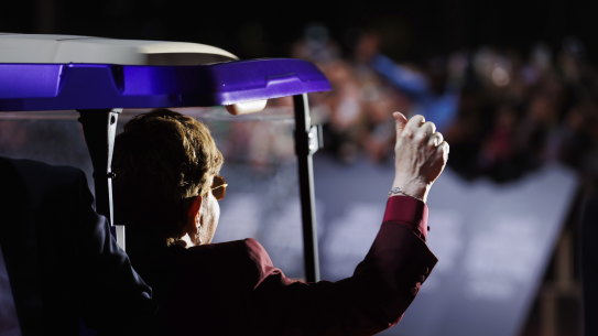 Elton John waves from a purple golf cart which delivered him to the red carpet in Toronto.