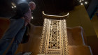 A visitor looks at the wooden and metal throne of the King Ghezo of the Dahomey kingdom.