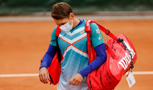 Short and sharp: Alex de Minaur leaves the court after losing to Marco Cecchinato in the first round.