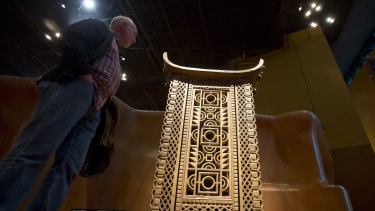 A visitor looks at the wooden and metal throne of the King Ghezo of the Dahomey kingdom.