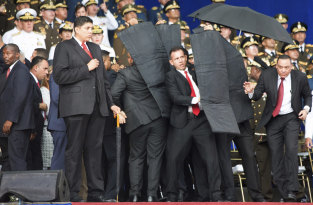 Security personnel surround Venezuela's President Nicolas Maduro in Caracas on Saturday after drones armed with explosives detonated as he gave a speech.