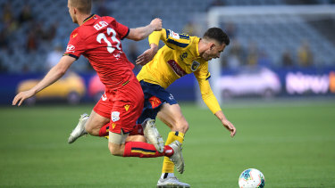 Jordan Murray of the Mariners is tackled by Adelaide United's Jordan Elsey.