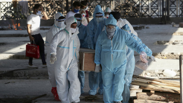 Health workers and relatives carry the body of a COVID-19 victim for cremation in Jammu, India.