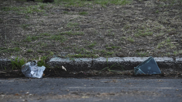 Broken glass lays in the gutter in the car space where Dr Reddy's car was found, with her body inside, in Kingsford. 