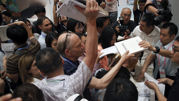 Reporters scramble to get copies of China's national defence white paper before a press conference at the State Council Information Office in Beijing on Wednesday.