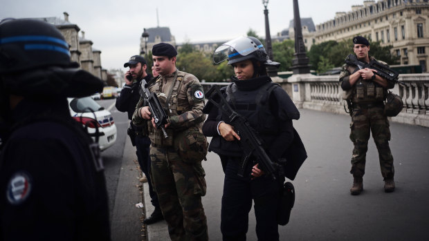 Armed police officers and soldiers on patrol after an assailant fatally stabbed four police officers inside the Paris police headquarters.