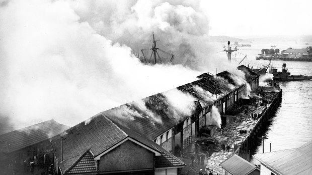 A spectacular waterfront fire at number 7 wharf at Campbell's Cove near Circular Quay in Sydney on 2 August 1944. This photos shows the view looking east with Fort Denison and Bennelong Point (where the Sydney Opera House now stands) visible in the distance.
