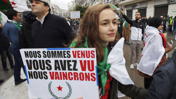 A demonstrator holds a placard that reads, we came, we saw, we conquered, during a protest in Algiers on Friday.