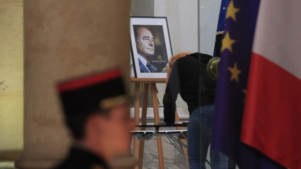 A woman signs a condolences book to pay tribute to former French president Jacques Chirac at the Elysee Palace in Paris.