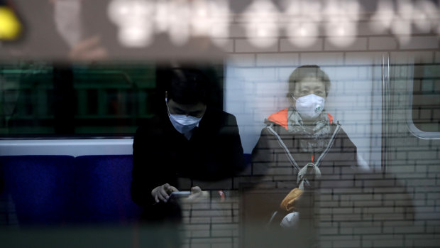 Commuters on the subway in Seoul, South Korea, wear masks to prevent the spread of coronavirus.