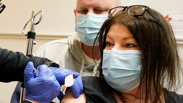 Keri Wegg receives her second COVID-19 vaccine shot as husband Rodney watches at IU Health North Hospital in Carmel, Indiana. 