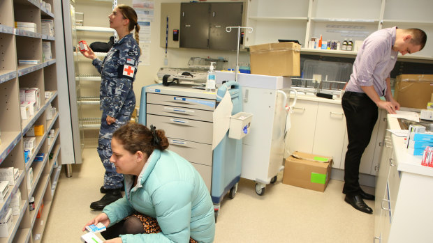Royal Australian Air Force and Tasmanian Health pharmacists replenishing stores in the North West Regional Hospital.
