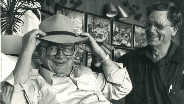 Wolf Stiebler, left, who commanded a German U-boat, tries on an Akubra in the company of Dudley Marrows, right, during a visit to Australia.