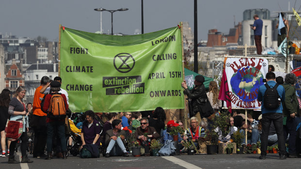 Protesters sit on the road of the blocked Waterloo Bridge in London on Wednesday. The group Extinction Rebellion is calling for a week of civil disobedience against what it says is the failure to tackle the causes of climate change.