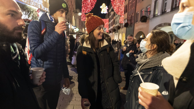 People enjoy a glass of mulled wine in the street before the curfew in Strasbourg, eastern France in December. The country was one of the first to introduce a tough lockdown last year, but soon relaxed the rules.