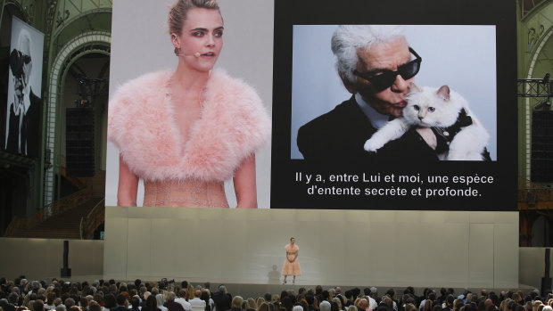 Model Cara Delevingne is seen on a giant screen as she speaks to the invited guests during "Karl for Ever" at the Grand Palais in Paris, France, on Thursday, June 20, 2019.