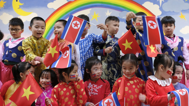 Children rehearse the welcoming ceremony with the national flags of Vietnam and North Korea. 