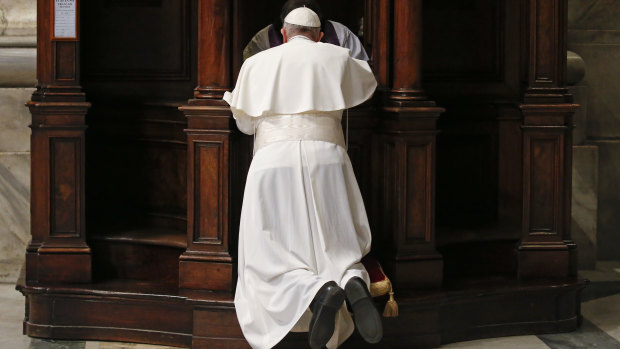 Pope Francis kneels in confession during a penitential liturgy in St. Peter's Basilica at the Vatican.