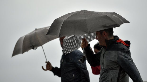 People shelter from the rain under their umbrellas, in San Sebastian, northern Spain on Sunday.