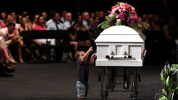 Hannah Clarke's nephew Tyler reaches to the coffin during the funeral for Hannah and her three children Aaliyah, Laianah and Trey.