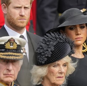 King Charles III, Camilla, the Queen Consort, Prince Harry and Meghan, Duchess of Sussex watch as the coffin of Queen Elizabeth II is placed into the hearse following the state funeral service in Westminster Abbey  last year.
