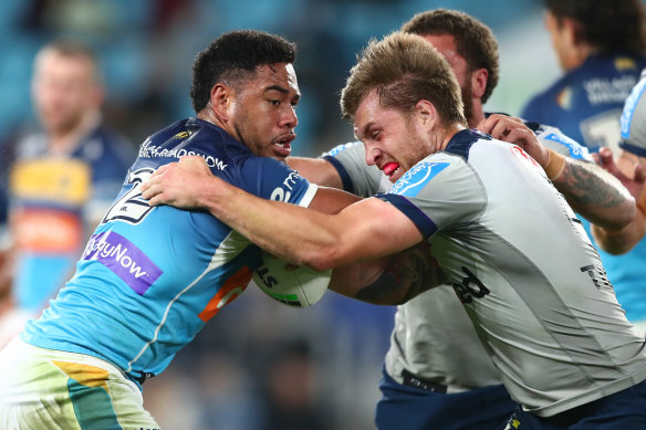 Greg Marzhew tries to break free from Melbourne’s Cameron Munster during his time at the Titans.