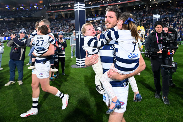 Isaac Smith of the Cats takes to the field with his family.