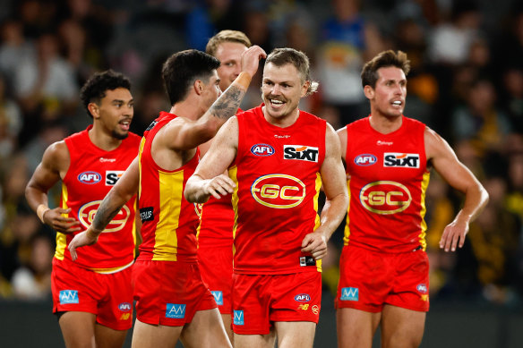 Nick Holman celebrates a goal with his Gold Coast teammates.