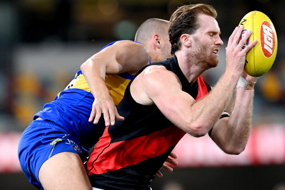 Essendon's James Stewart comes under pressure from West Coast's Dom Sheed.