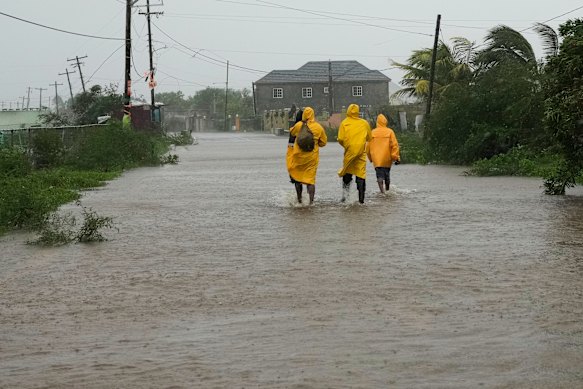 People walk along a road during the passing of Hurricane Melissa in Rocky Point, Jamaica, 