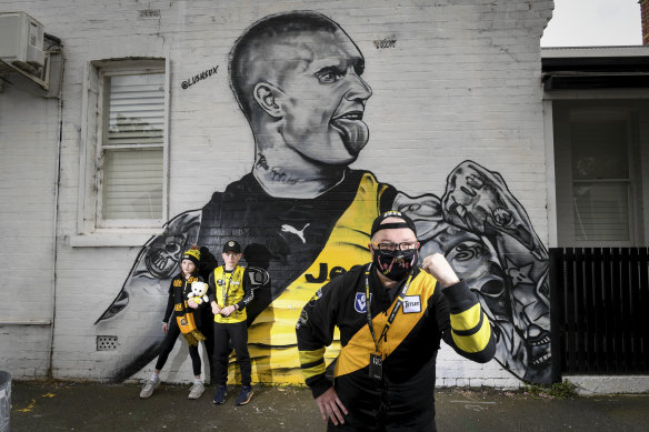 Paying tribute: Josh Rowe and children Madeline and Archie at the Lushsux mural of Richmond footballer Dustin Martin in Kelso Street, Richmond.