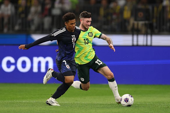Joel Chima Fujita of Japan and Aiden O’Neill of the Socceroos compete for the ball
