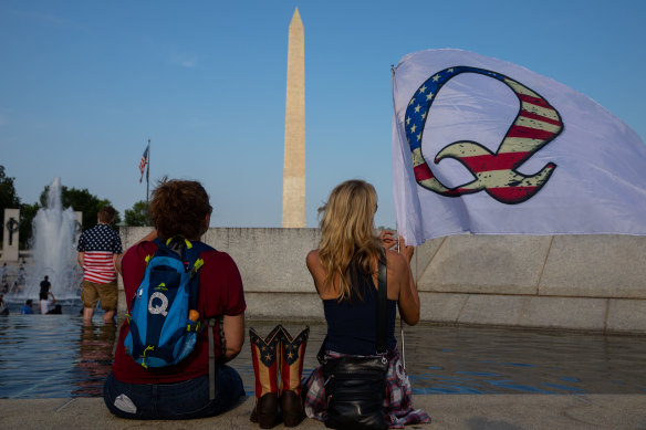 QAnon supporters wait for a military flyover at the World War II Memorial during 2020 Fourth of July celebrations in Washington.