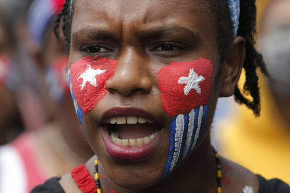 A Papuan student with her face painted with the colours of the separatist 'Morning Star' flag shouts slogans during a rally near the presidential palace in Jakarta, Indonesia, on August 29.