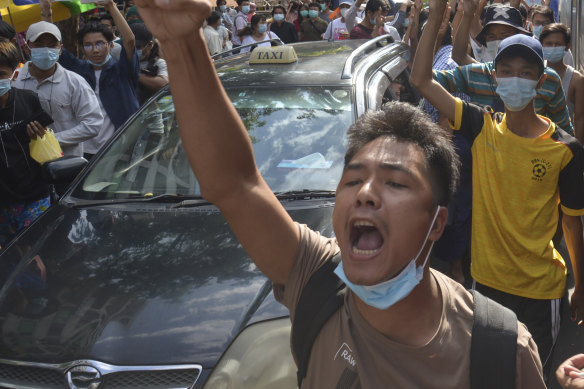 Anti-coup protesters shout slogans during a flash-mob demonstration on Thursday, in Yangon, Myanmar.