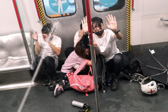 Police shoot pepper spray at protesters inside a train at Prince Edward Station, in Hong Kong.
